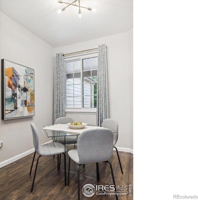 dining space with a notable chandelier and dark hardwood / wood-style floors