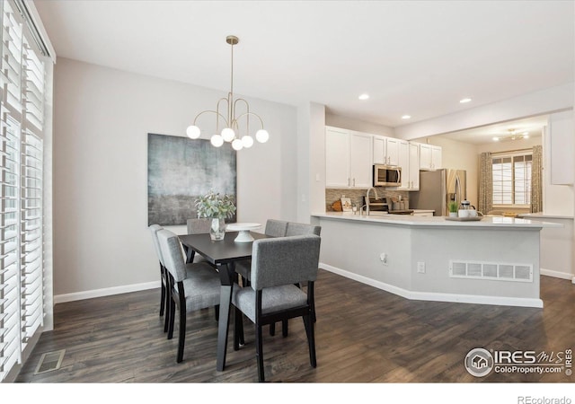 dining space featuring dark hardwood / wood-style flooring and a chandelier