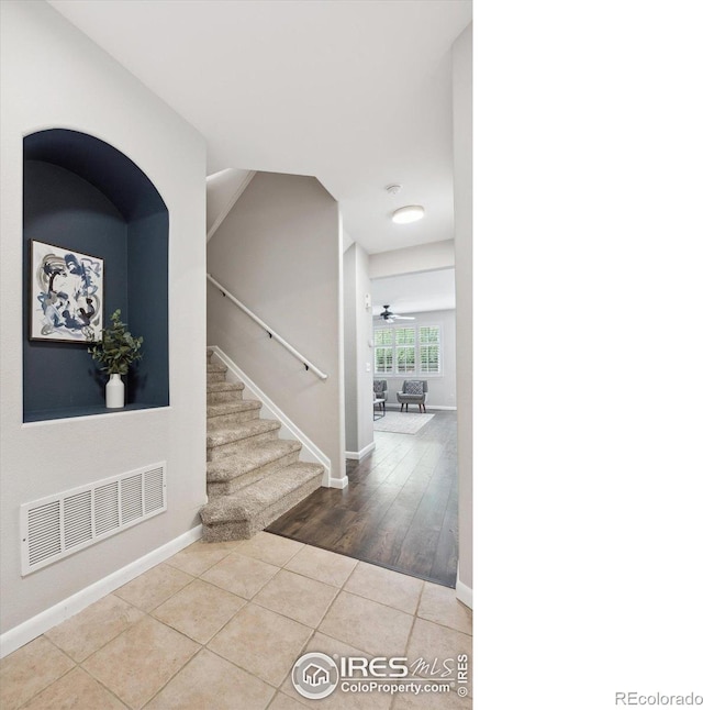 tiled entryway featuring ceiling fan