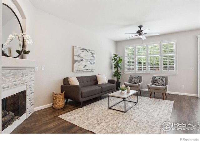 living room featuring dark hardwood / wood-style flooring, a fireplace, and ceiling fan