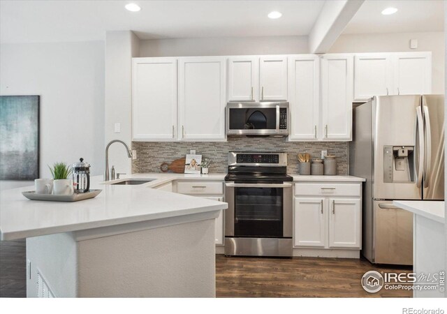 kitchen with sink, white cabinets, tasteful backsplash, and appliances with stainless steel finishes