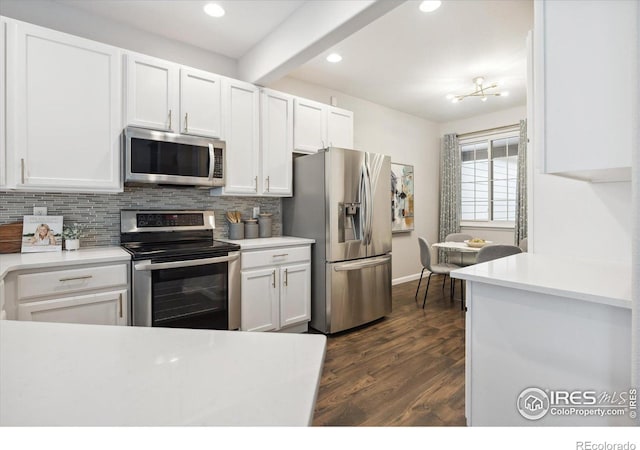 kitchen featuring white cabinets, stainless steel appliances, and beam ceiling