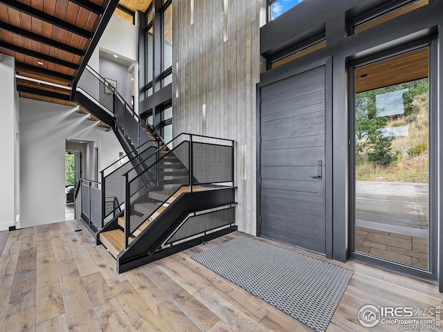 interior space featuring a high ceiling, wood ceiling, wood-type flooring, and a wealth of natural light