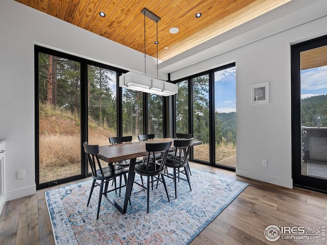 dining area with wood ceiling and hardwood / wood-style floors