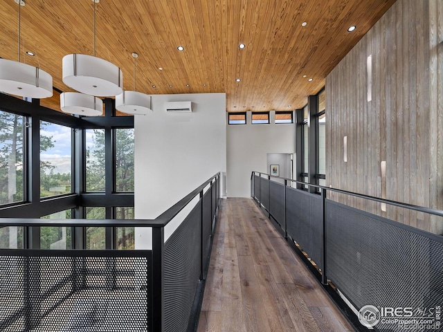 kitchen with hardwood / wood-style floors, wood walls, a wall mounted AC, and decorative light fixtures