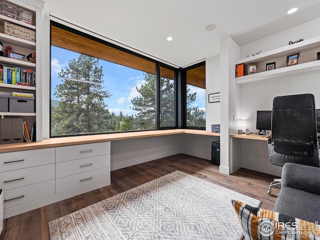 office area with built in features, hardwood / wood-style floors, and built in desk