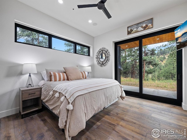 bedroom with access to outside, dark hardwood / wood-style floors, ceiling fan, and multiple windows