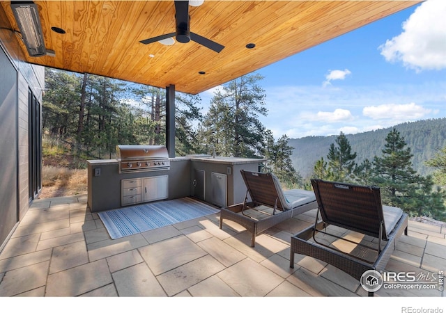 view of patio / terrace featuring area for grilling, a mountain view, and ceiling fan