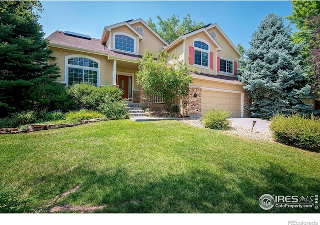 view of front of house with a garage, a front yard, and solar panels