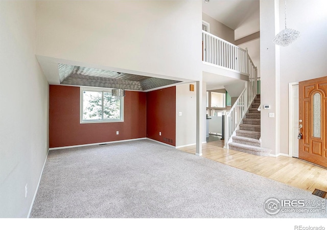 entrance foyer featuring a towering ceiling and carpet floors