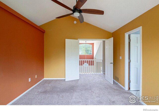 unfurnished room with lofted ceiling, light colored carpet, and ceiling fan