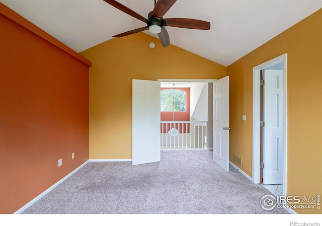 carpeted empty room featuring vaulted ceiling and ceiling fan