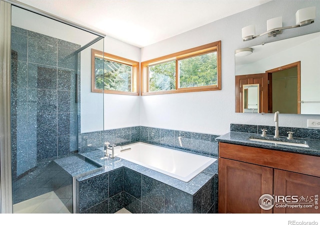 bathroom featuring plus walk in shower and vanity