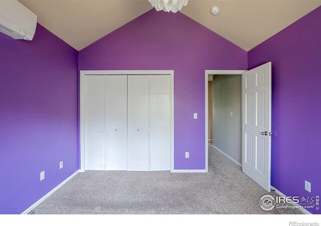 unfurnished bedroom featuring light colored carpet, a closet, vaulted ceiling, and a wall mounted air conditioner