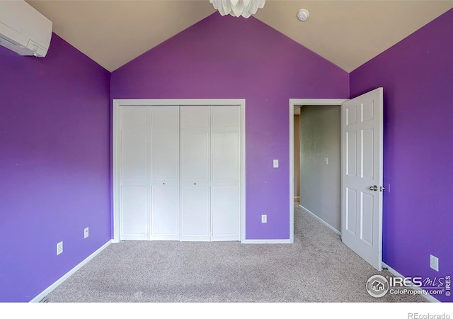 unfurnished bedroom with vaulted ceiling, an AC wall unit, carpet, and a closet