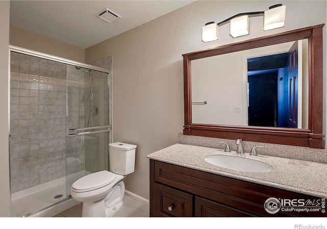 bathroom featuring walk in shower, toilet, vanity, and tile patterned flooring