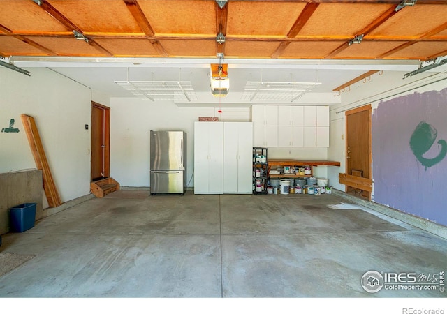 garage featuring stainless steel fridge and a garage door opener