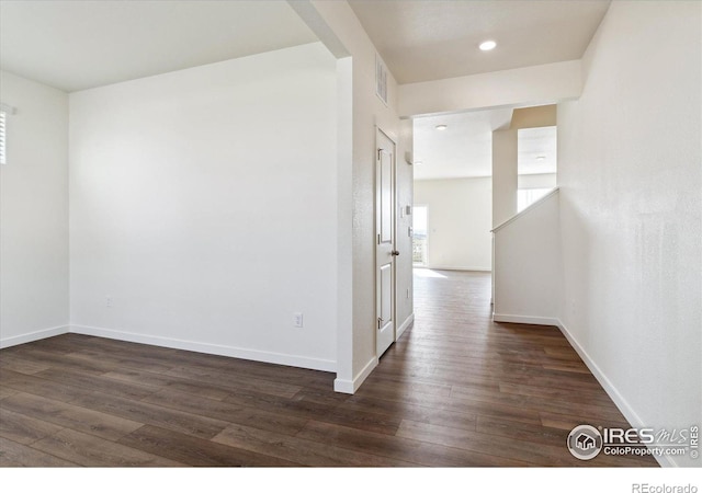 hallway featuring recessed lighting, dark wood finished floors, visible vents, and baseboards