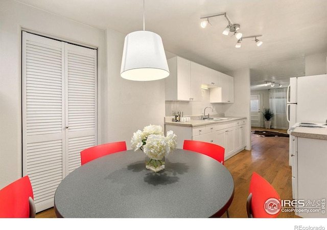 dining room with sink, track lighting, ceiling fan, and light hardwood / wood-style floors