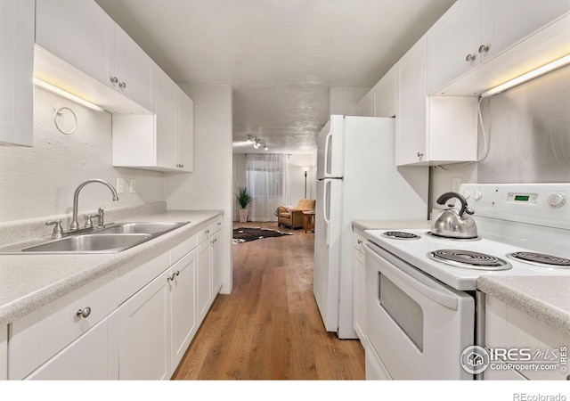 kitchen with white cabinets, sink, electric range, and light hardwood / wood-style floors