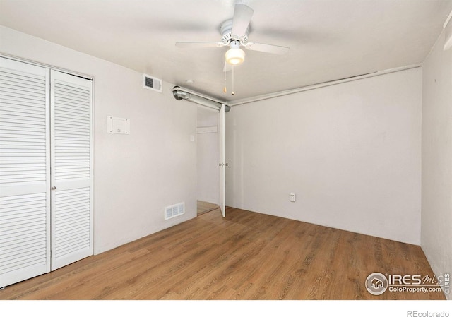 unfurnished bedroom featuring ceiling fan, hardwood / wood-style floors, and a closet