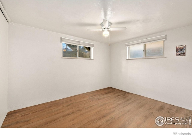 unfurnished room featuring ceiling fan, wood-type flooring, and a healthy amount of sunlight