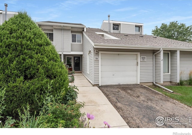 townhome / multi-family property featuring driveway, a garage, and roof with shingles