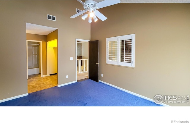 unfurnished bedroom with ceiling fan, carpet floors, and a high ceiling