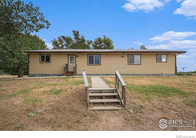 single story home with entry steps and a front lawn