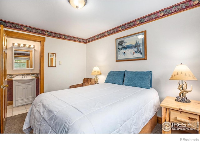 bedroom featuring sink, connected bathroom, and light tile patterned floors