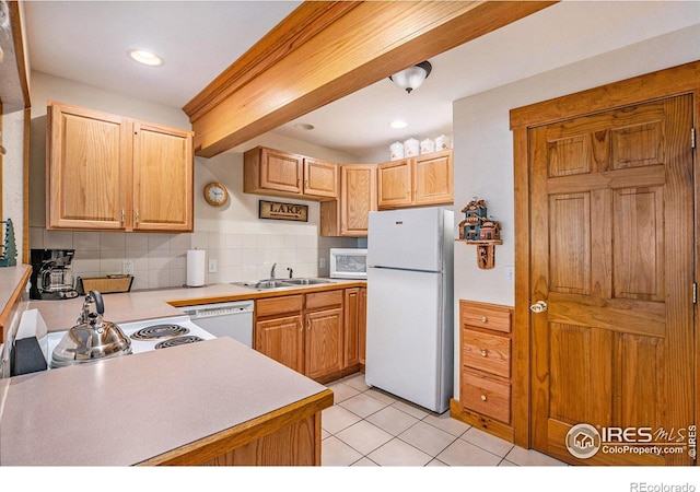 kitchen with tasteful backsplash, white appliances, light brown cabinets, light tile patterned floors, and sink