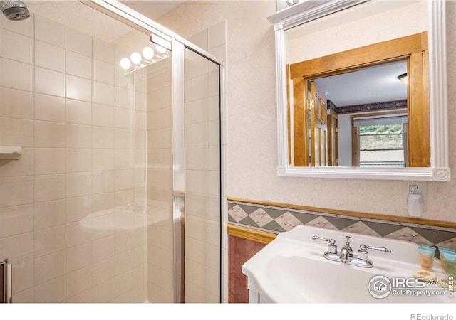 bathroom featuring sink, tile walls, and an enclosed shower