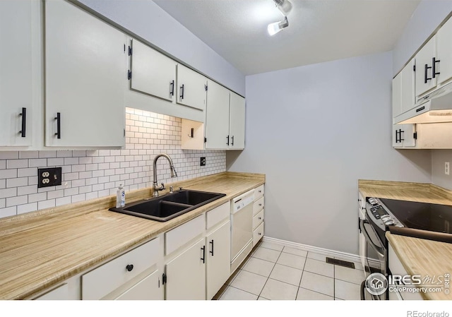 kitchen featuring decorative backsplash, sink, light tile patterned floors, dishwasher, and white cabinetry