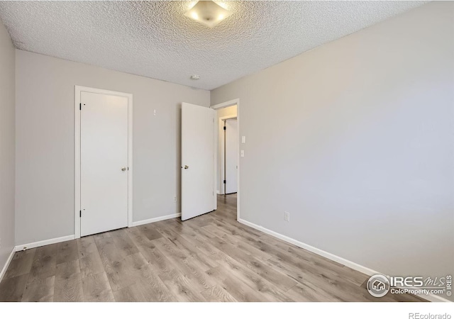 unfurnished bedroom featuring a textured ceiling and light hardwood / wood-style flooring