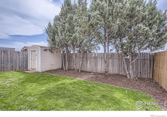 view of yard featuring a storage shed, a fenced backyard, and an outbuilding