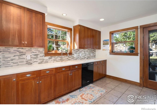 kitchen with light tile patterned floors, black dishwasher, tasteful backsplash, and sink