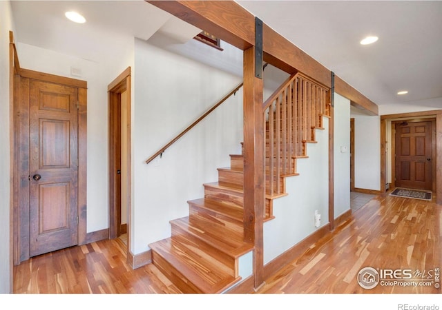 stairs featuring a barn door and hardwood / wood-style floors