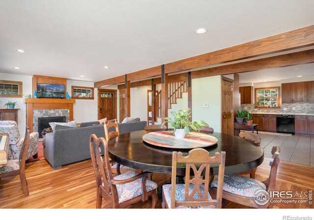 dining area featuring a fireplace, light wood-type flooring, and sink