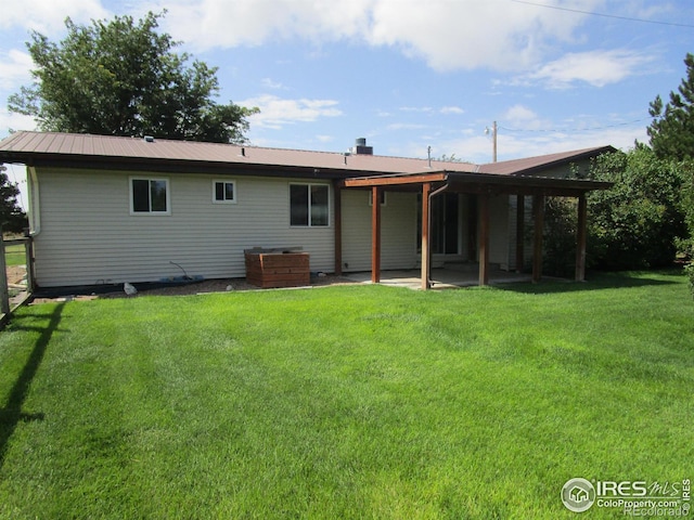 rear view of property with a lawn and a patio