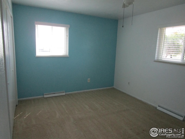 spare room featuring a baseboard radiator and carpet