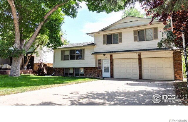 tri-level home featuring a front yard and a garage