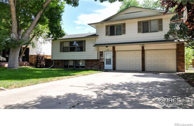 split level home with a garage and a front lawn