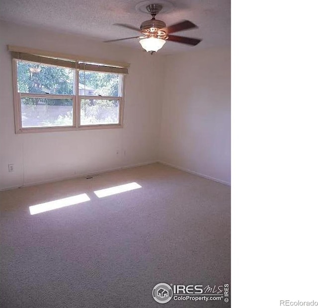 carpeted empty room with ceiling fan and a textured ceiling