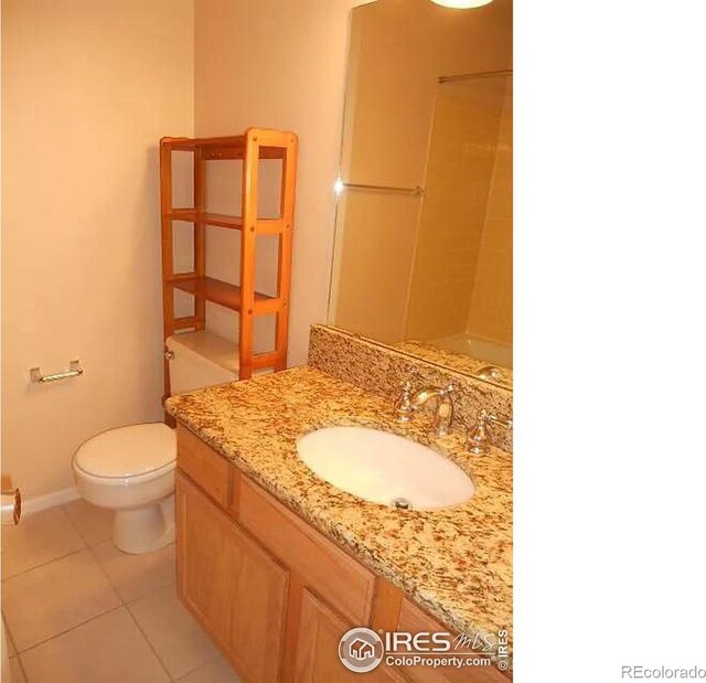 bathroom featuring toilet, vanity, and tile patterned flooring