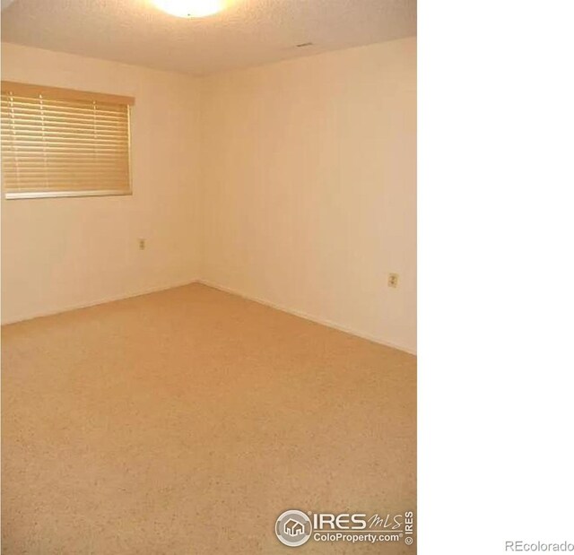 unfurnished room featuring carpet floors and a textured ceiling