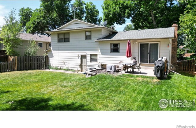 rear view of property with a patio and a lawn