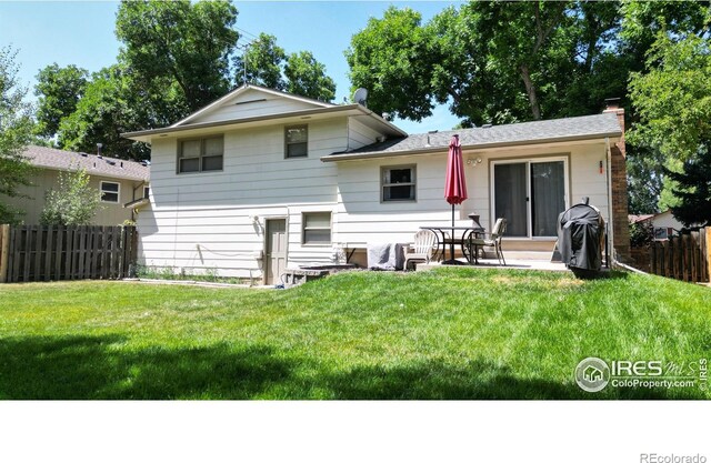 rear view of house featuring a lawn and a patio area