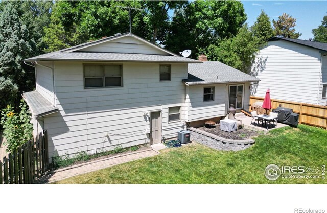 back of house featuring a patio area, central AC unit, and a lawn