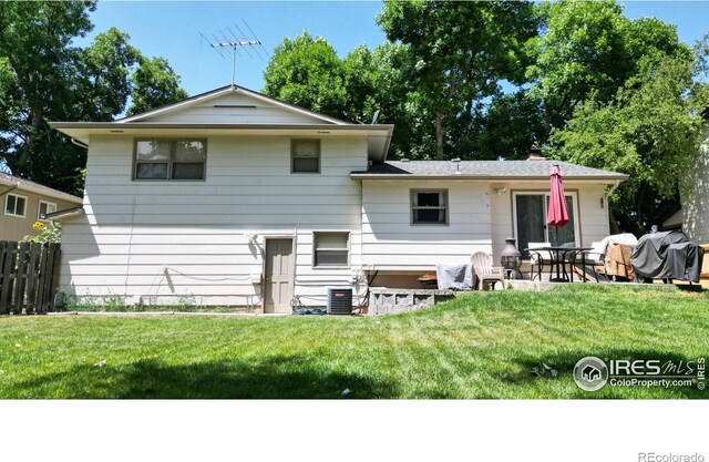 rear view of property with a patio, a yard, and central air condition unit