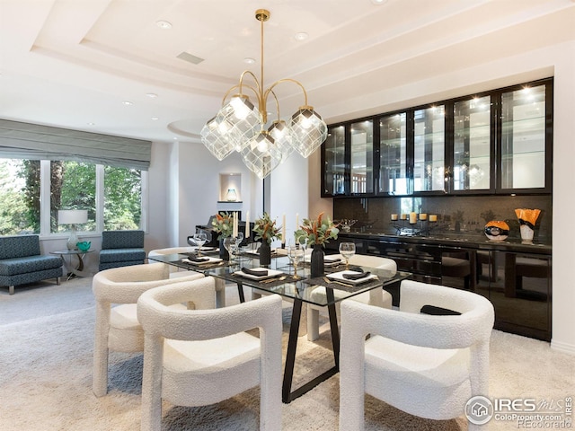 dining room with a raised ceiling, light carpet, recessed lighting, and indoor wet bar